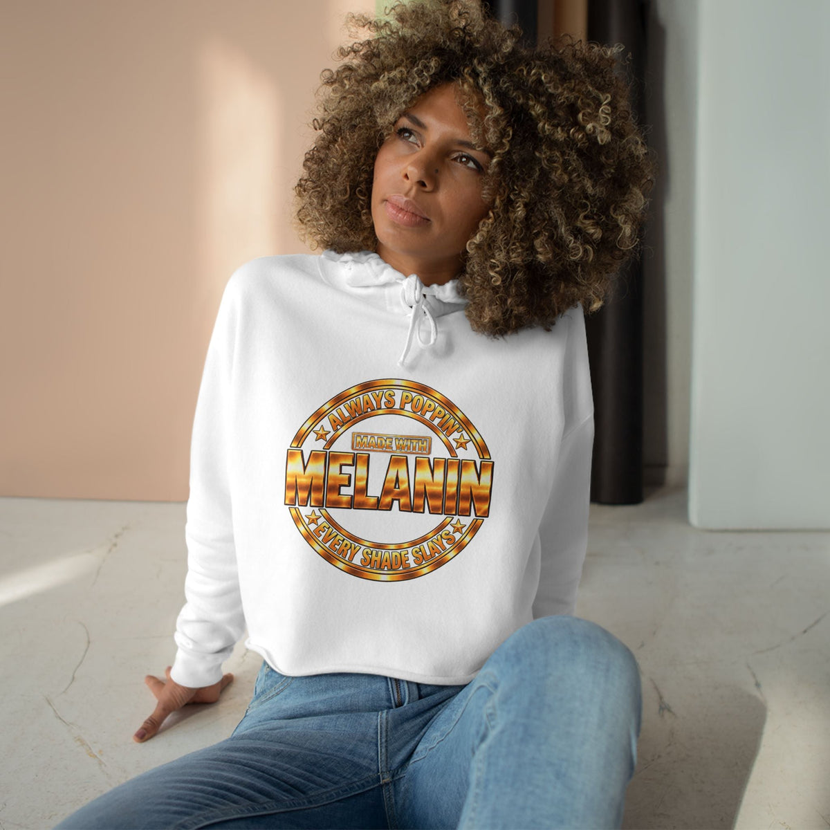 Made with Melanin graphic crop hoodie with a metallic-toned circular design.