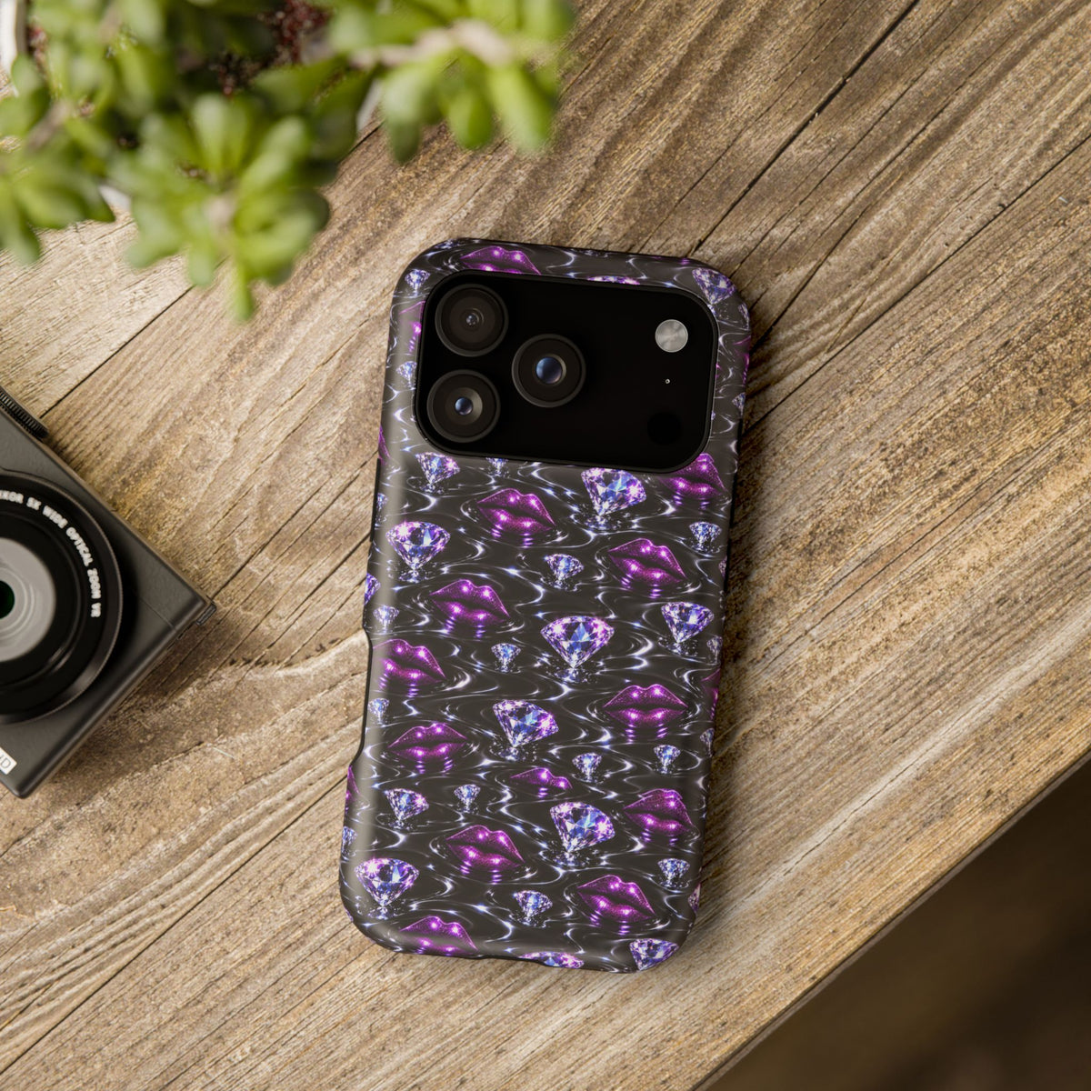 Purple lips and diamond motifs on a black graphic phone case.