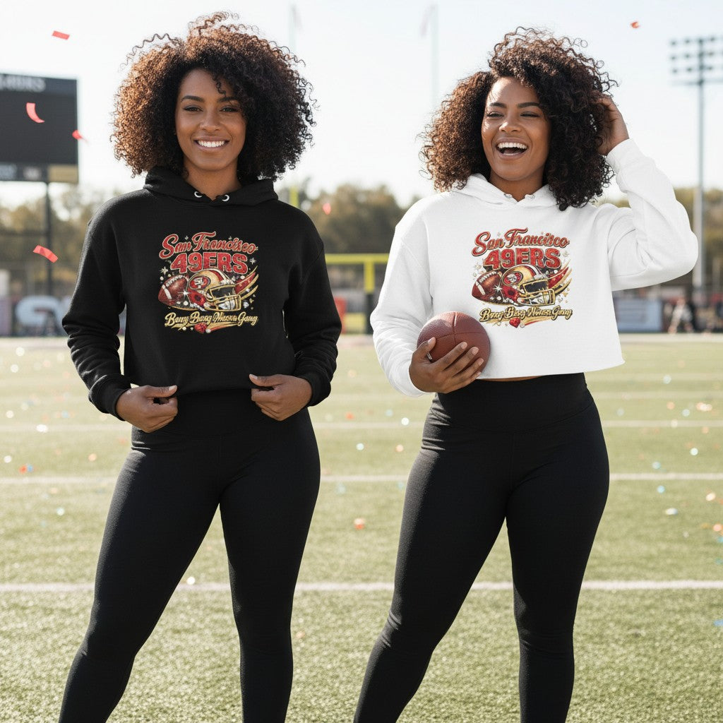 Two women wearing Throw it in the Bag San Francisco 49ers cropped hoodies in black and white on a football field.
