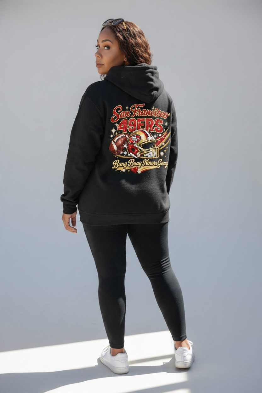 Woman wearing a Throw it in the Bag black San Francisco 49ers fleece hoodie with vintage team graphics on the back
